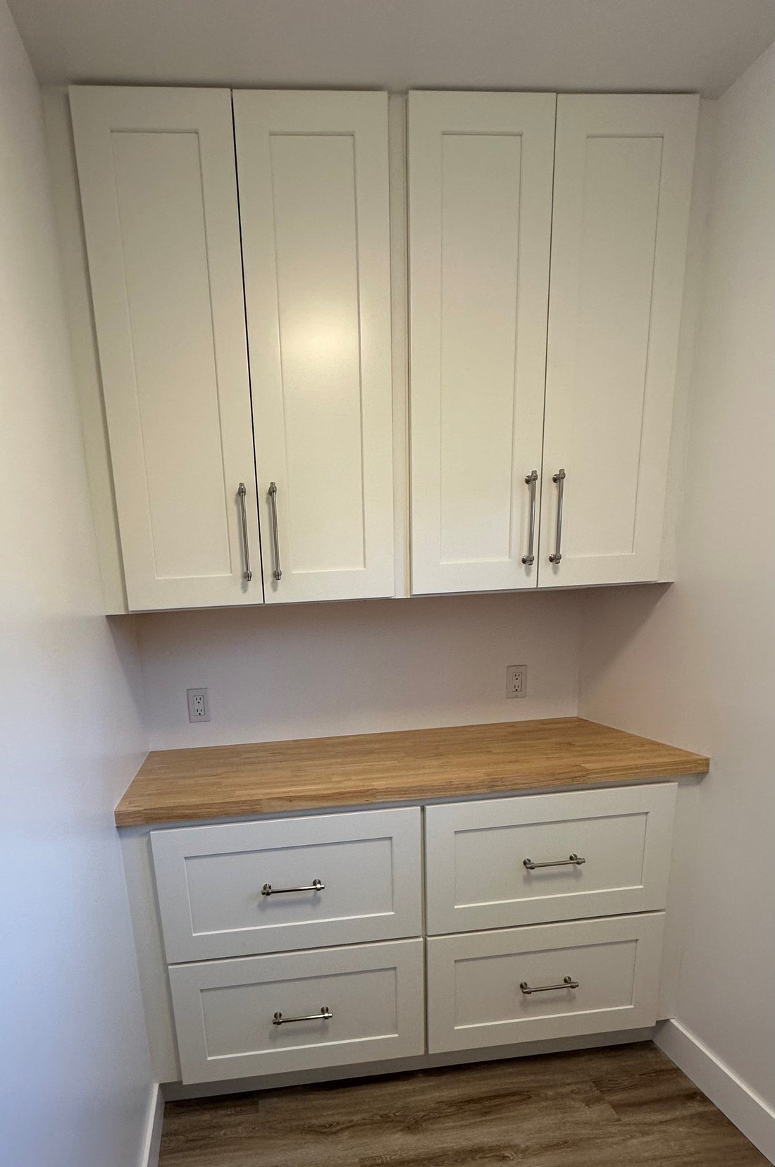 White Shaker cabinets in a laundry room.  The base cabinets comprise of two 27" wide two drawer bases (2DB27).  On top there are two 27" wide, 42" high wall cabinets (W2742).